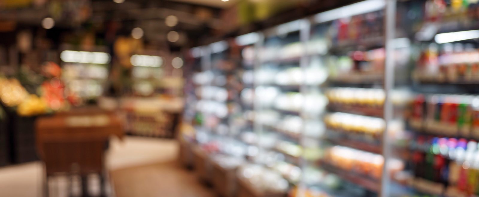 Defocused Image Of Food And Drink On Shelves In Illuminated Store