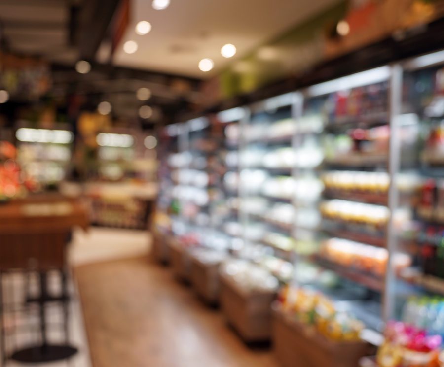 Defocused Image Of Food And Drink On Shelves In Illuminated Store