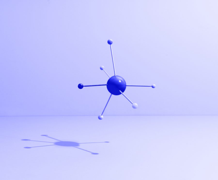 Conceptual still life with colored sticks attached to a sphere, symbolizing teamwork