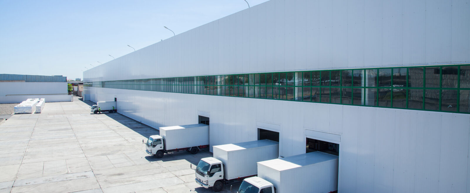 facade of an industrial building and warehouse with freight cars in length