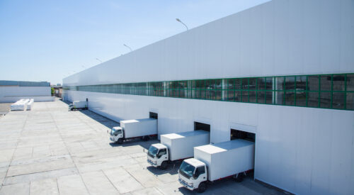 facade of an industrial building and warehouse with freight cars in length