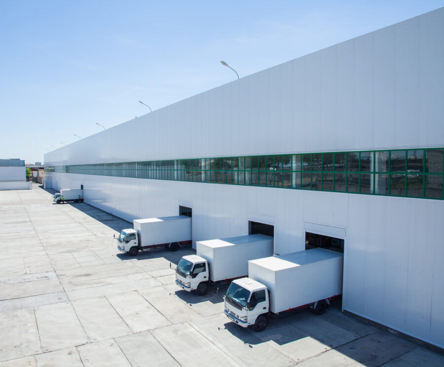 facade of an industrial building and warehouse with freight cars in length