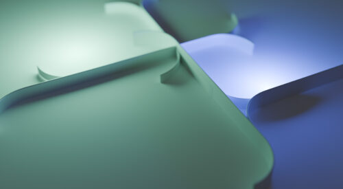 Interlocking three-dimensional, blue and green shapes within an image suggestive of progress
