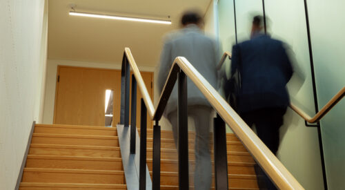 Two men walking up a staircase