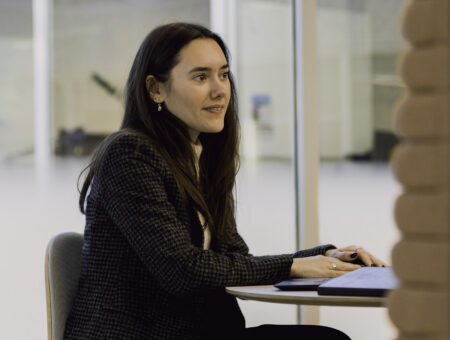 Woman sat at table, looking across