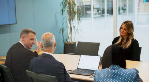 Colleagues gather around a table in ICG's London office