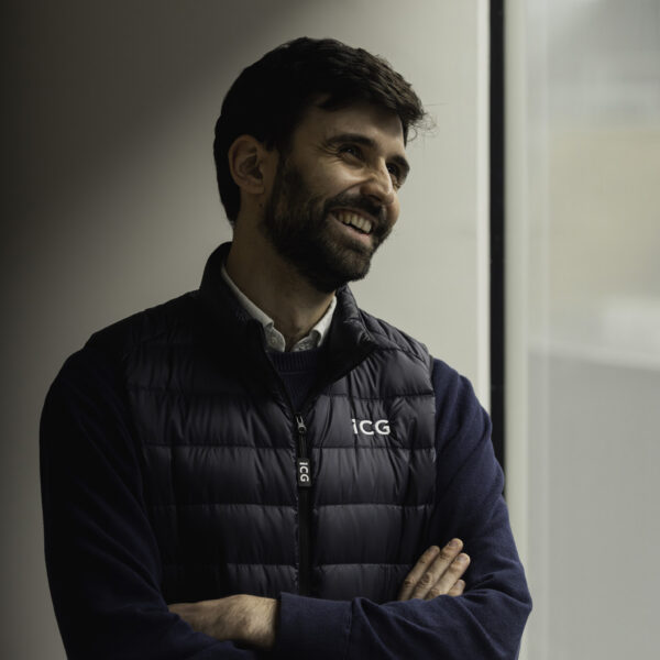 Man looking out a window, wearing an ICG gilet