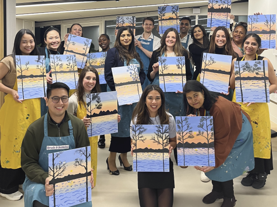 Group photo, with colleagues holding paintings
