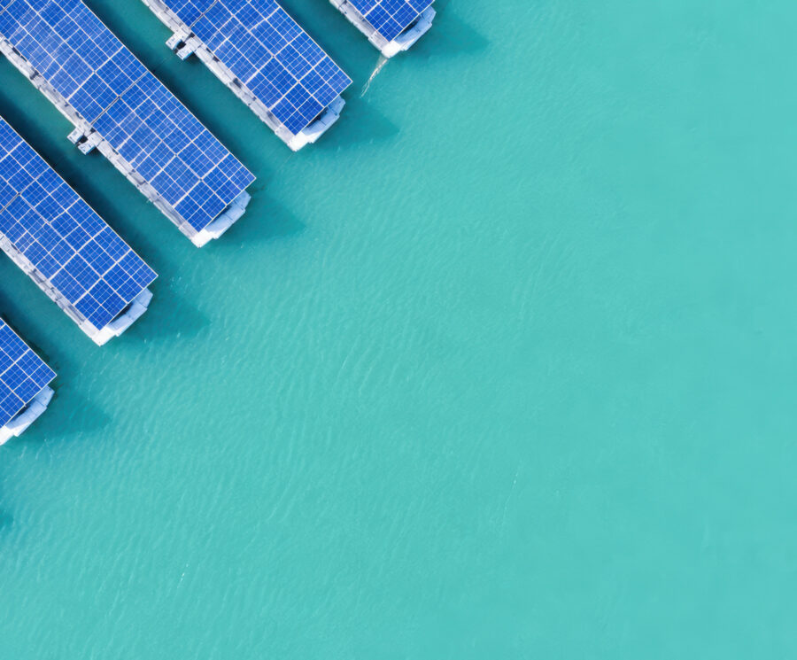 A top-down photo of floating solar panels on turquoise water